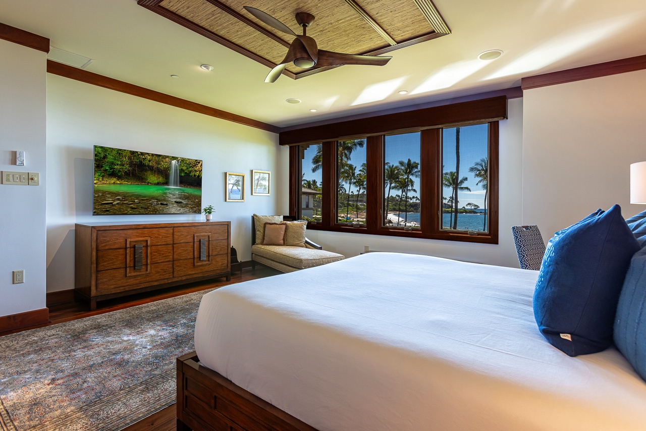 Wake up to stunning ocean views framed by tropical palms and rich wood accents. This spacious retreat features plush bedding, island-inspired design, and a window seat perfect for enjoying coastal beauty.