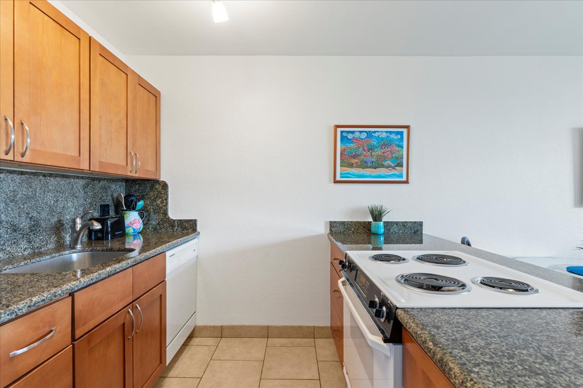 Your fully equipped galley kitchen features granite countertops, warm wood cabinetry, and everything you need to prepare your favorite meals in comfort.