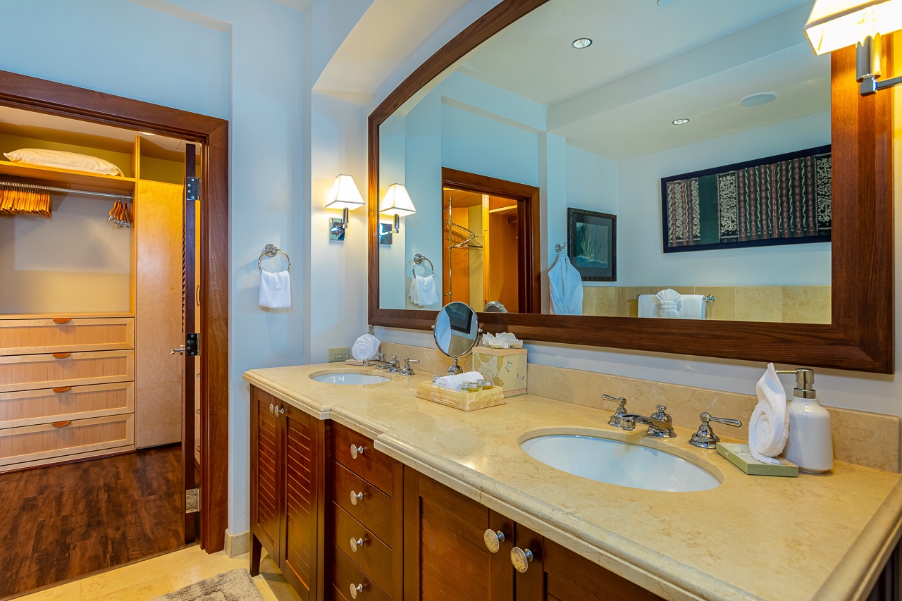 Step into your elegantly appointed bathroom with dual vanities and warm wood finishes. Soft lighting and plush towels create a spa-like retreat where you can unwind after a day of island adventures.