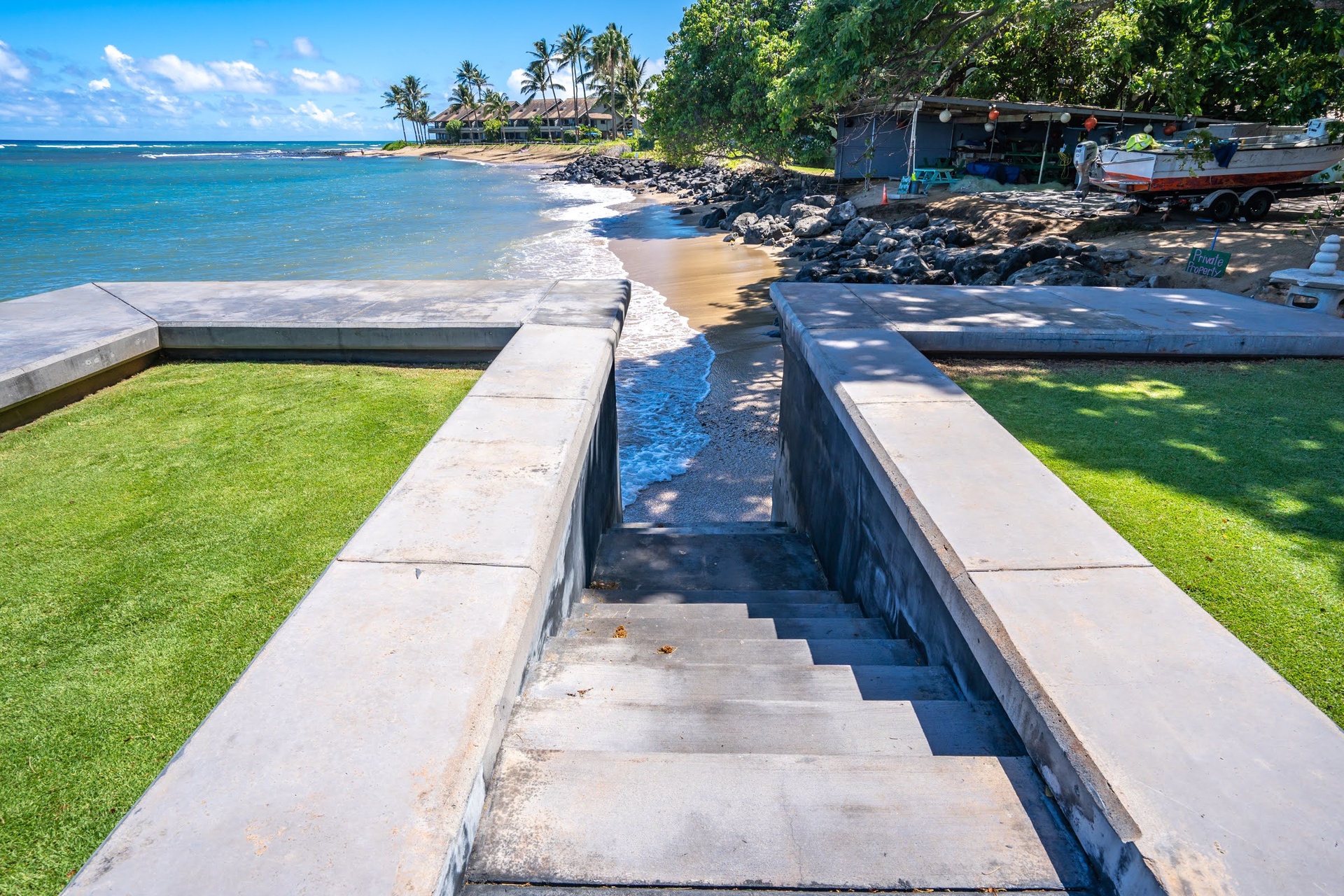 Beachfront property with direct access to sandy shores and turquoise waters, surrounded by lush tropical palms and natural coastal beauty.