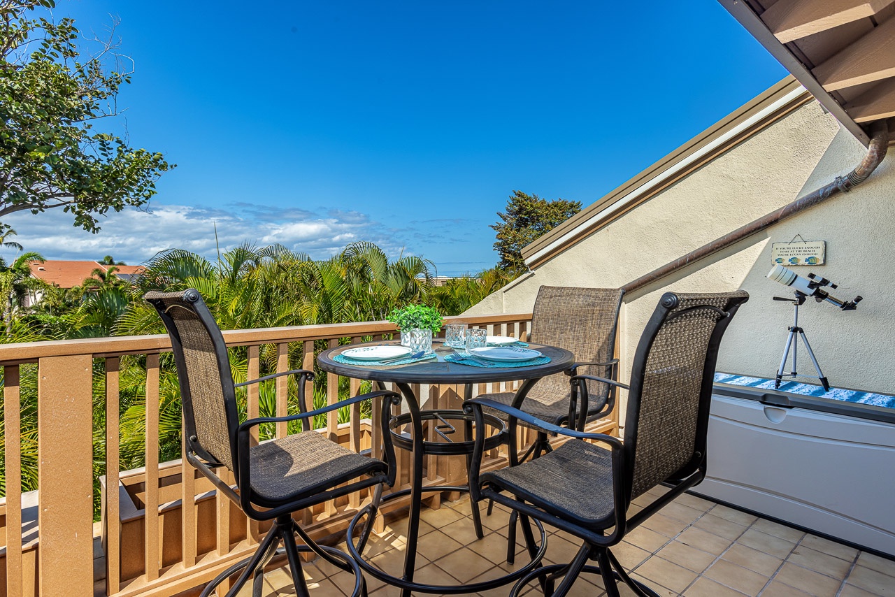 Sip your morning coffee at this private balcony table, surrounded by lush palm trees and tropical greenery under clear blue skies.