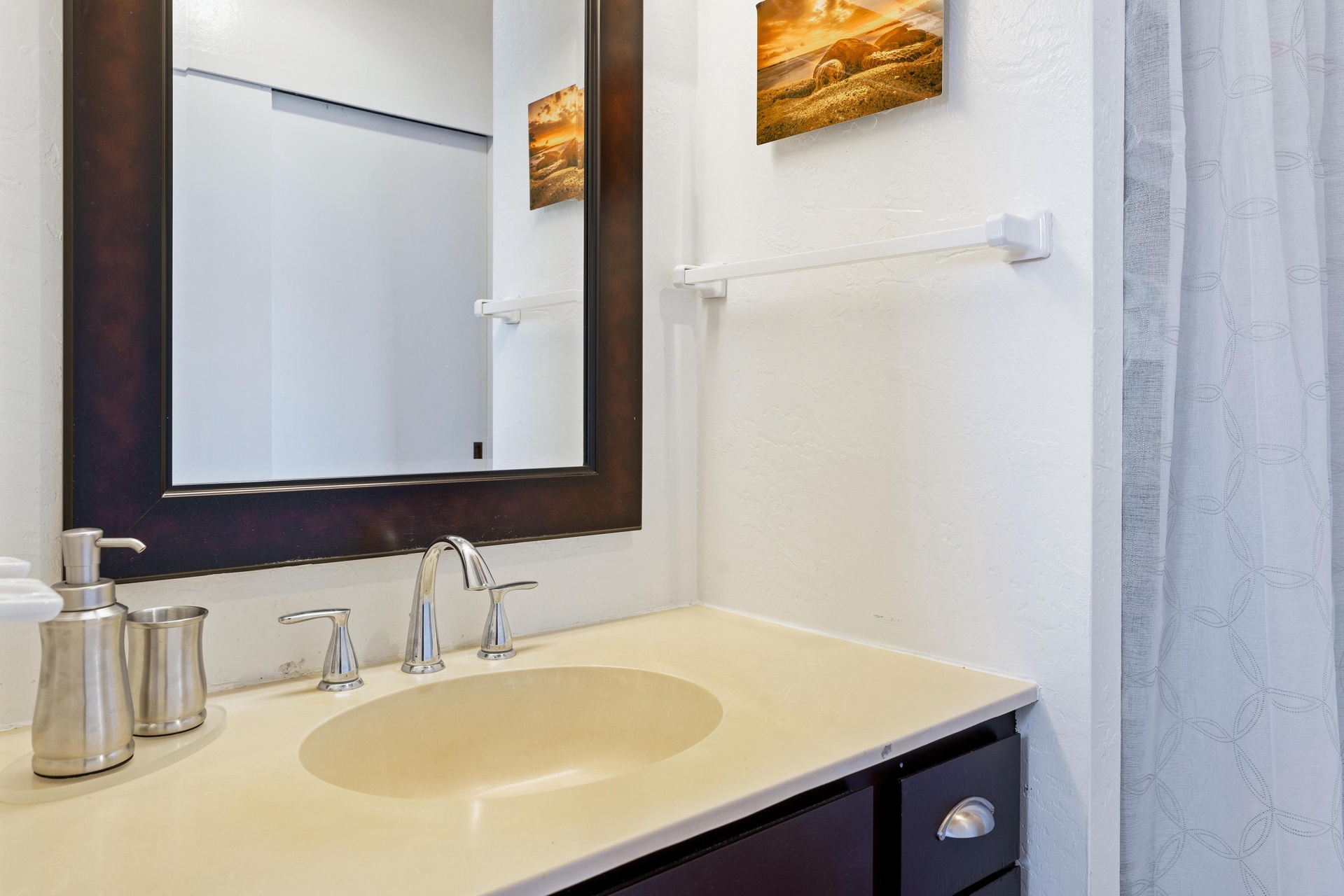 Freshen up in your private bathroom, complete with a polished vanity, soft towels, and coastal artwork that brings the beach right to your door.