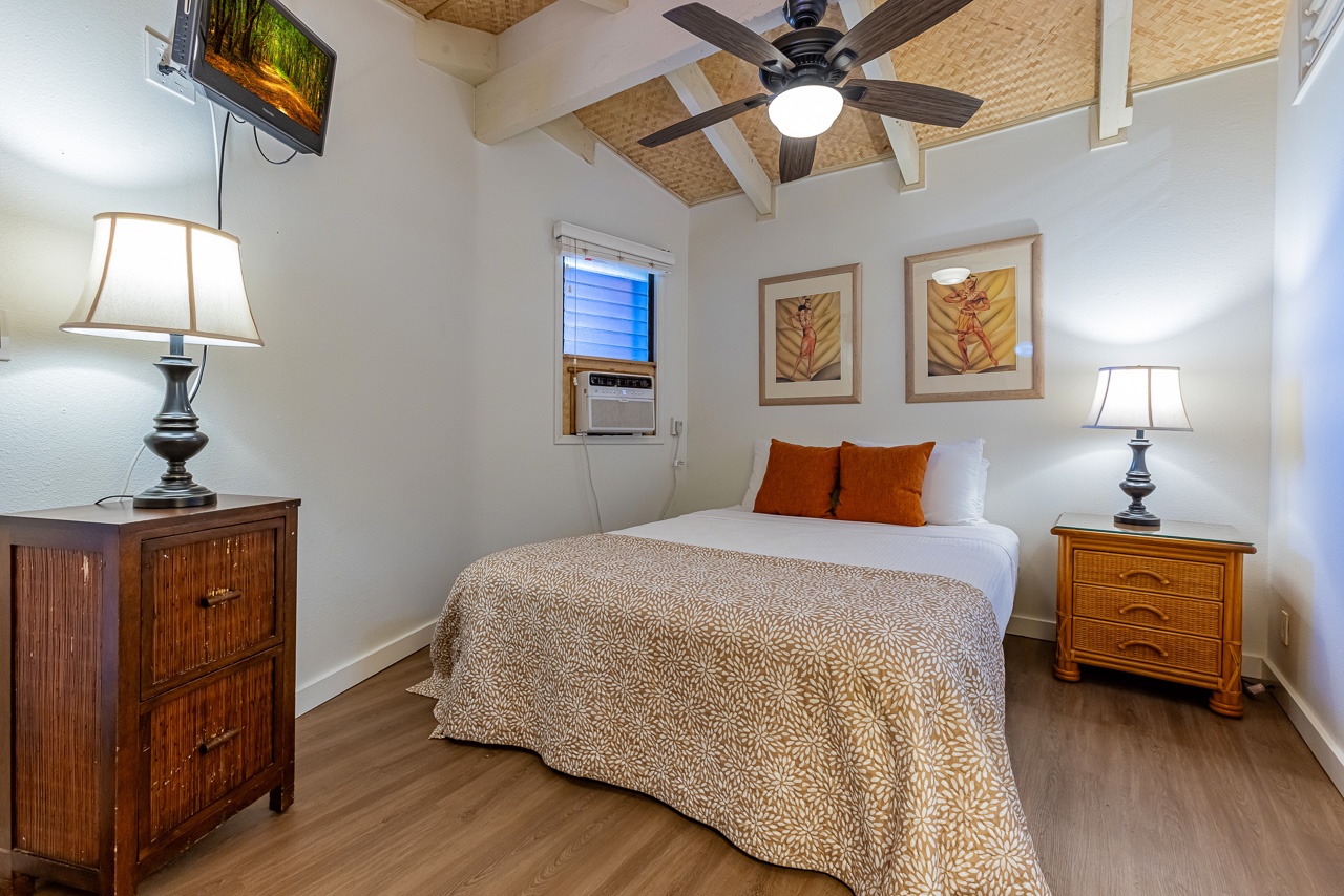 Your peaceful island-inspired bedroom features a plush queen bed, warm tropical accents, and a ceiling fan to keep you cool during balmy evenings.