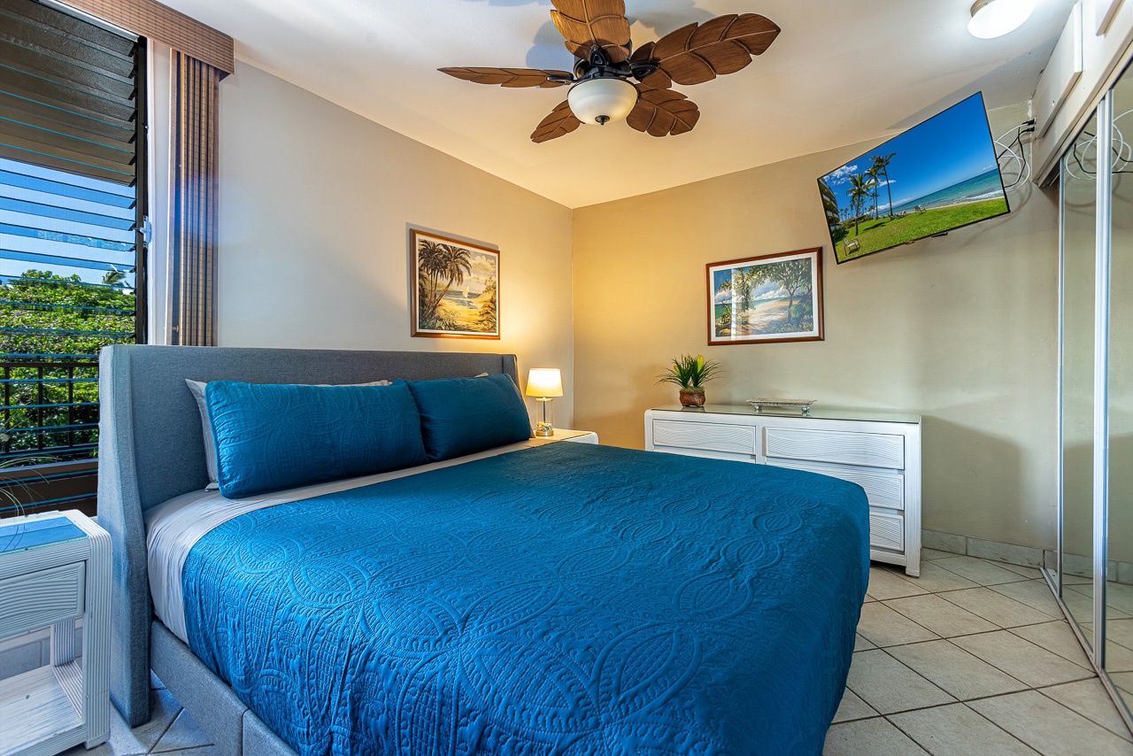 Step into your serene coastal retreat with a plush bed dressed in calming ocean blues, gentle ceiling fan breezes, and warm tropical touches. Relax and recharge in comfort.