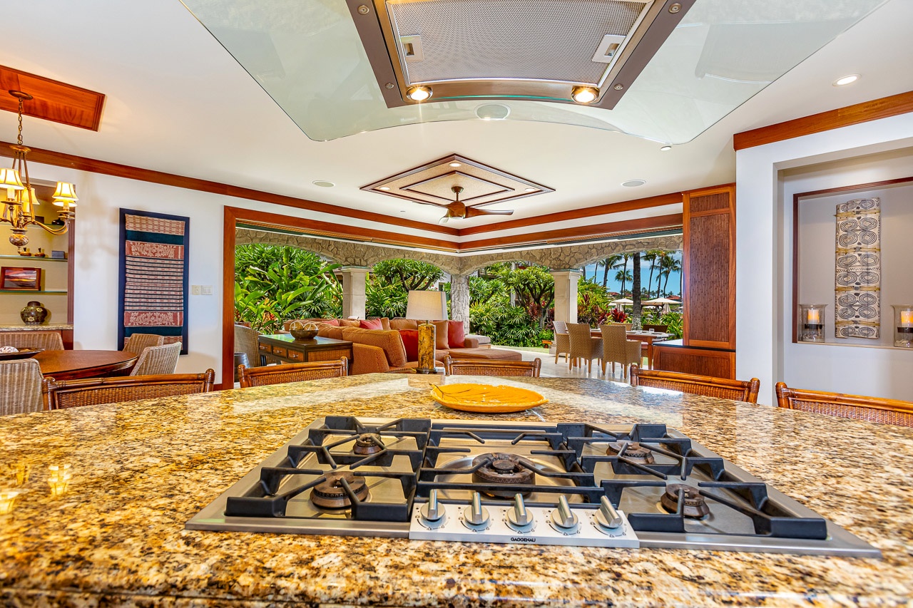 Your gourmet kitchen opens directly to lush tropical gardens and ocean breezes, blending indoor elegance with island paradise just steps away.