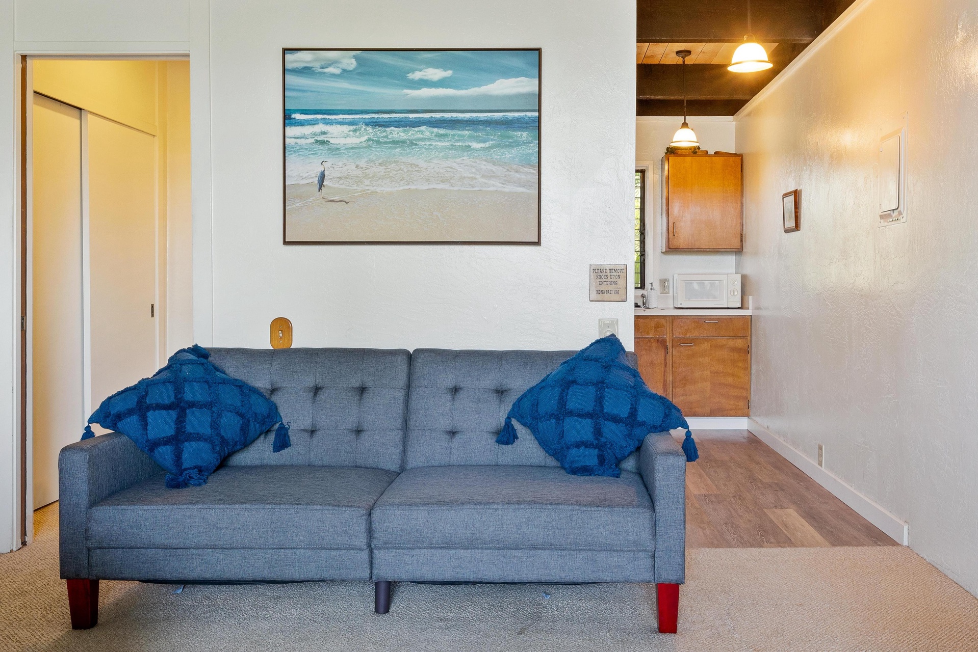 Sink into the plush sofa and let the coastal artwork transport you to serene beaches, while your kitchenette awaits for easy meal prep in this inviting, light-filled retreat.