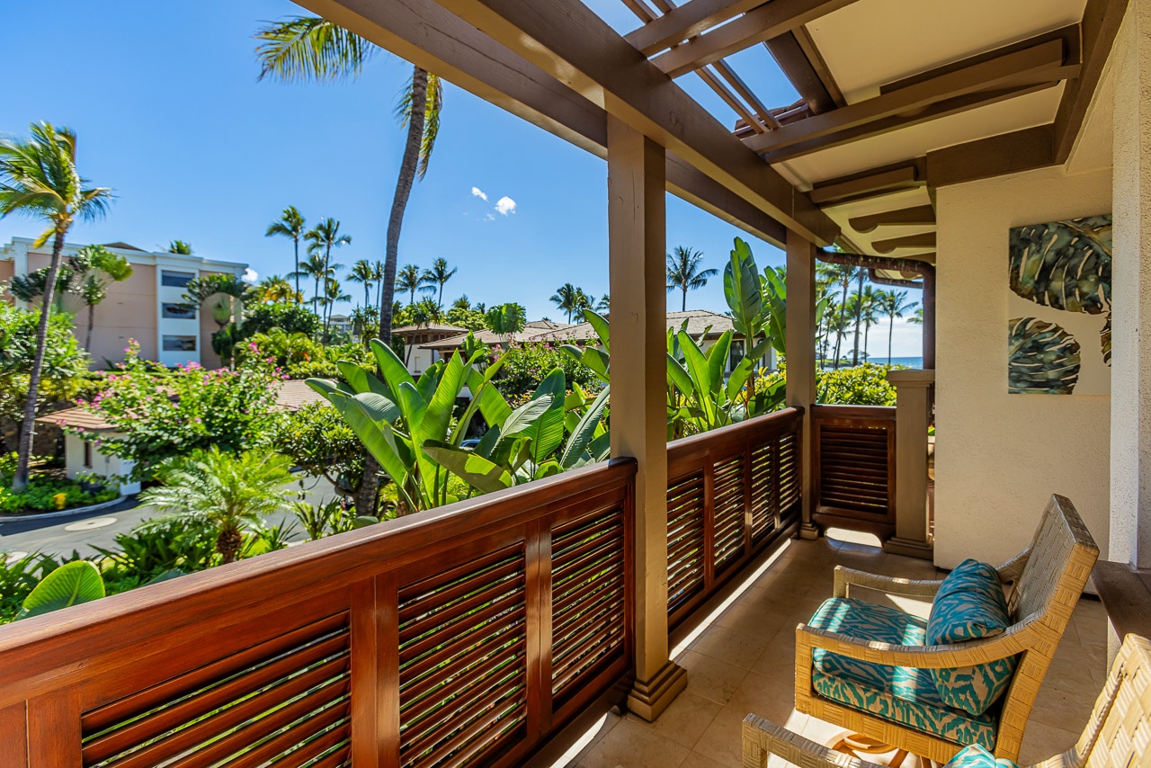 This covered lanai frames a lush tropical setting with swaying palms and lush greenery beyond. Settle into the cushioned seating and take in the tranquil escape at your doorstep.
