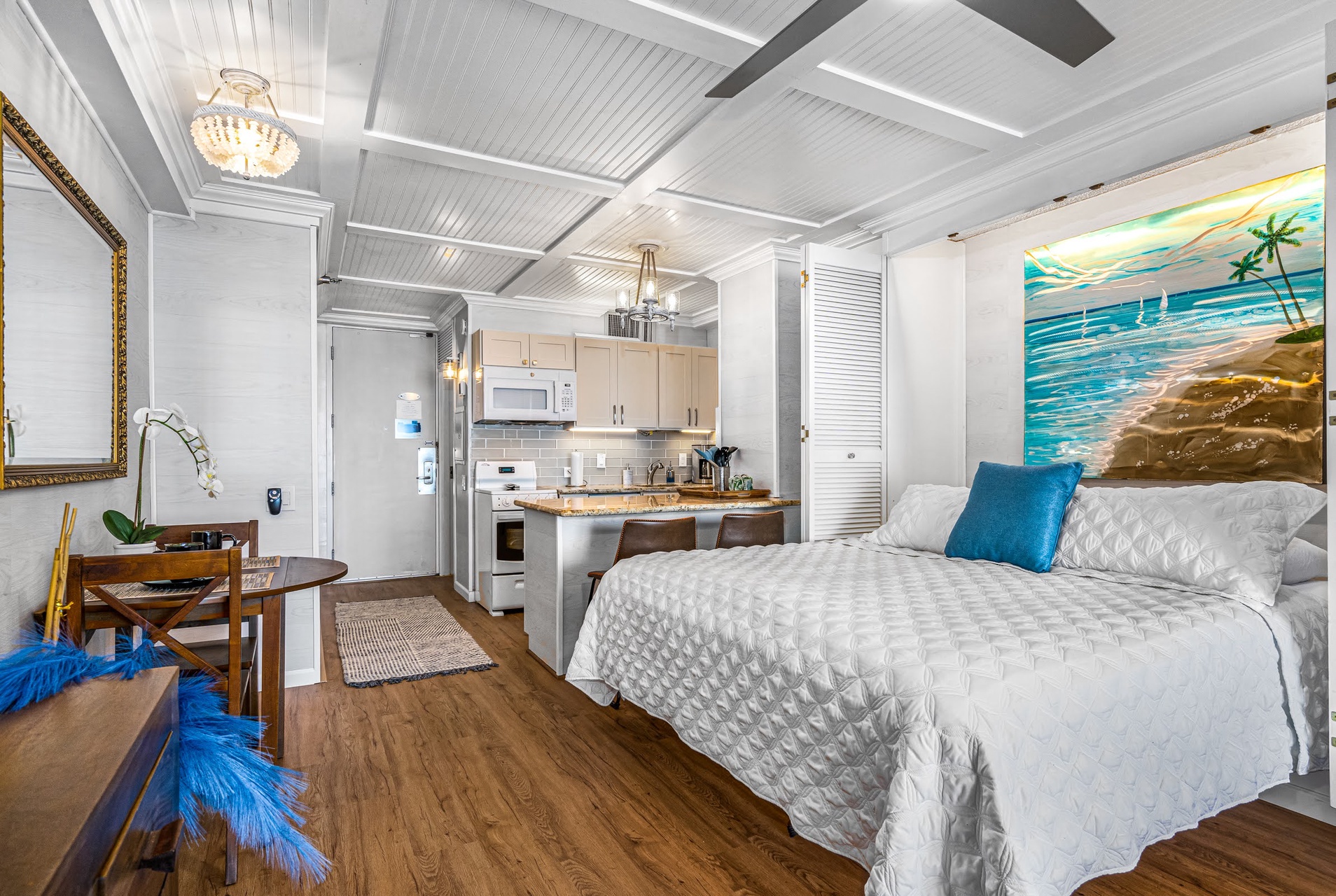 Relax in your cozy studio retreat with elegant coffered ceilings, a gleaming chandelier, and a fully equipped kitchenette.