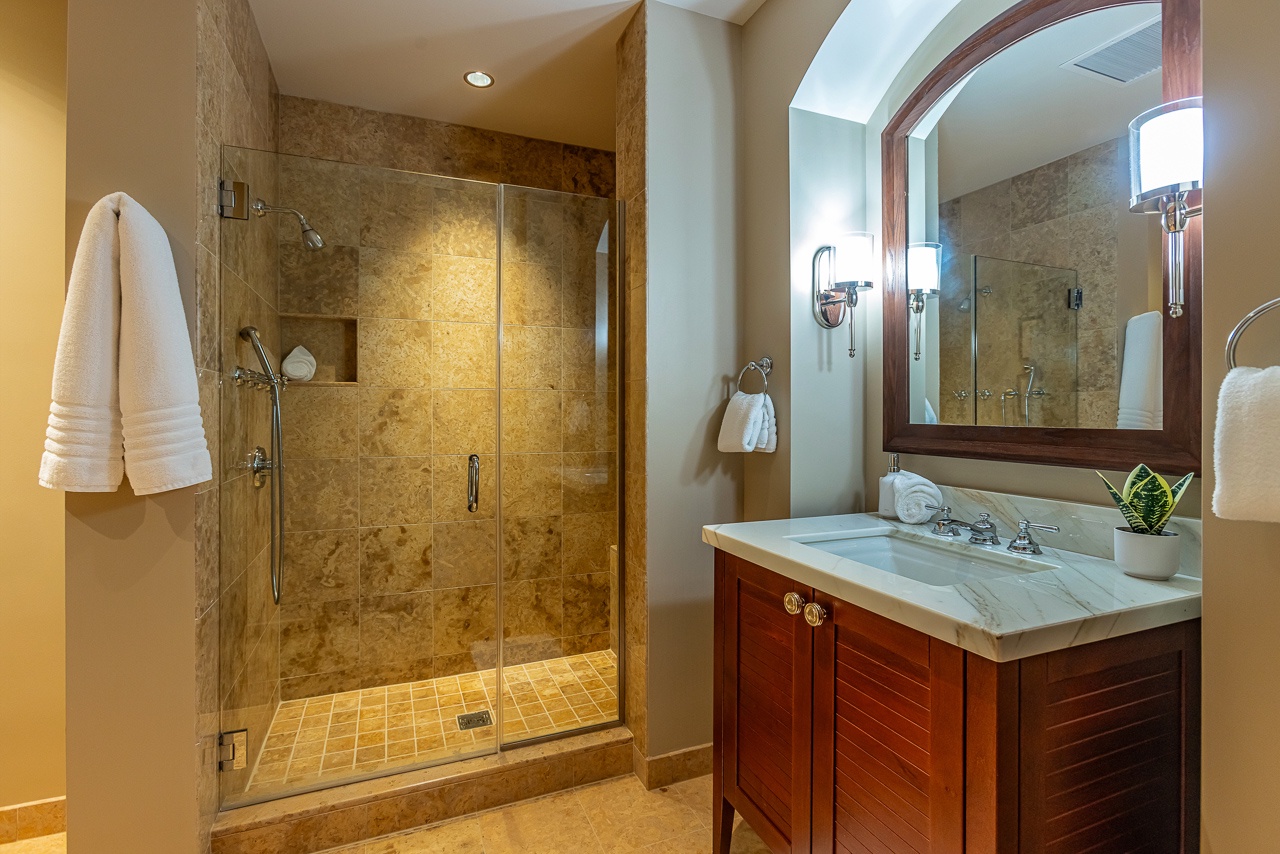 Step into your spa-like bathroom where gleaming marble and warm wood welcome you. The spacious glass-enclosed shower beckons after a day of adventure, while plush towels await on the heated rack.
