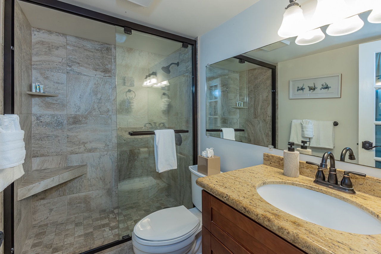 Indulge in your private spa-like bathroom with elegant granite counters, spacious glass shower, and luxurious marble accents.