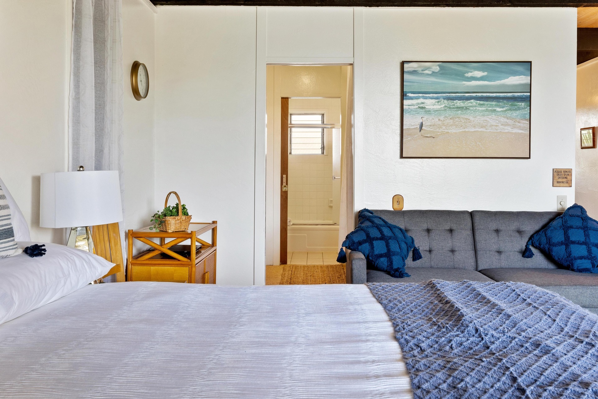 Sink into the plush bedding and let coastal vibes wash over you. Your private beach-inspired retreat offers soothing tones, a comfy sofa for lounging, and a serene view into your ensuite bathroom.