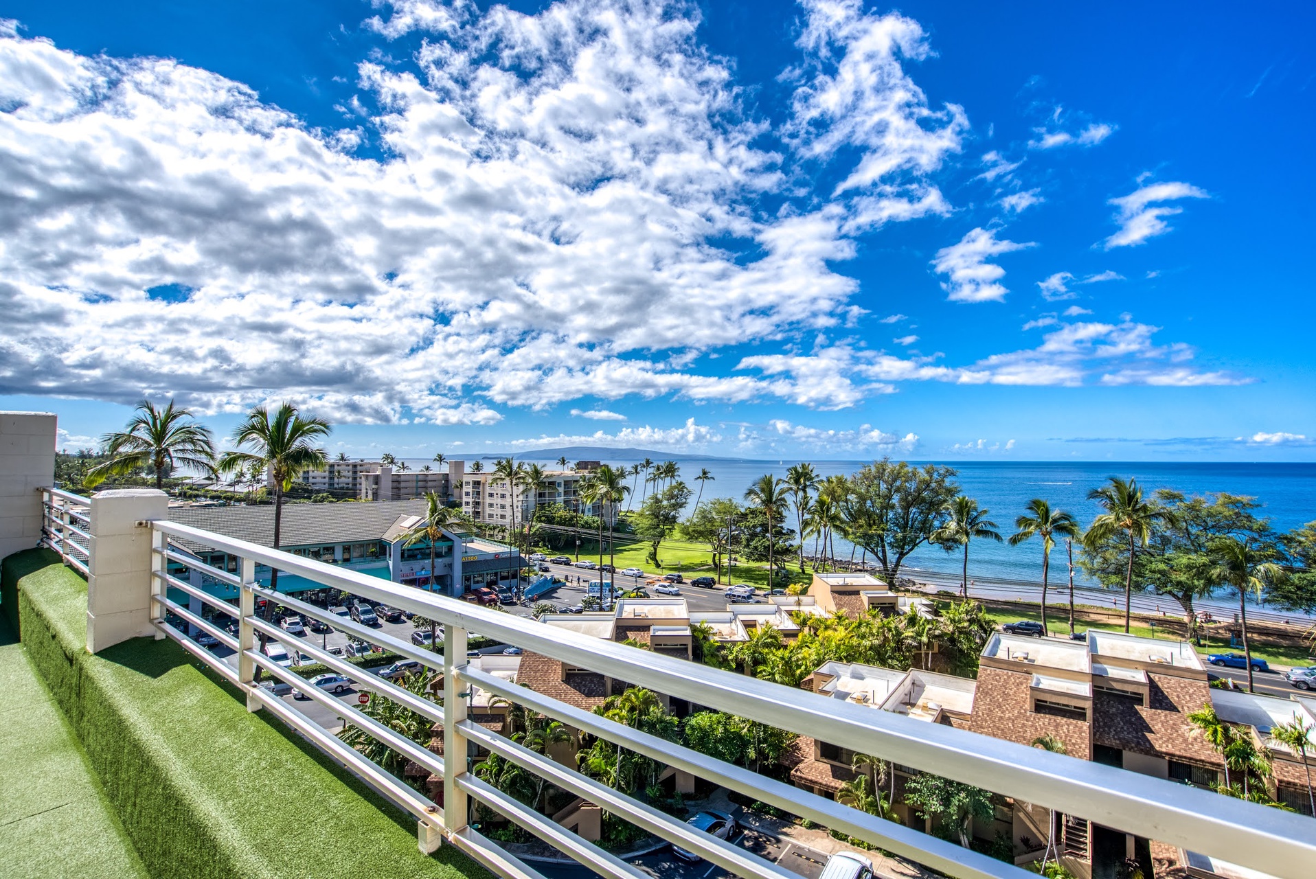 A tropical paradise unfolds before you—swaying palms, azure ocean, and endless blue skies frame your private balcony retreat where every morning feels like a dream.