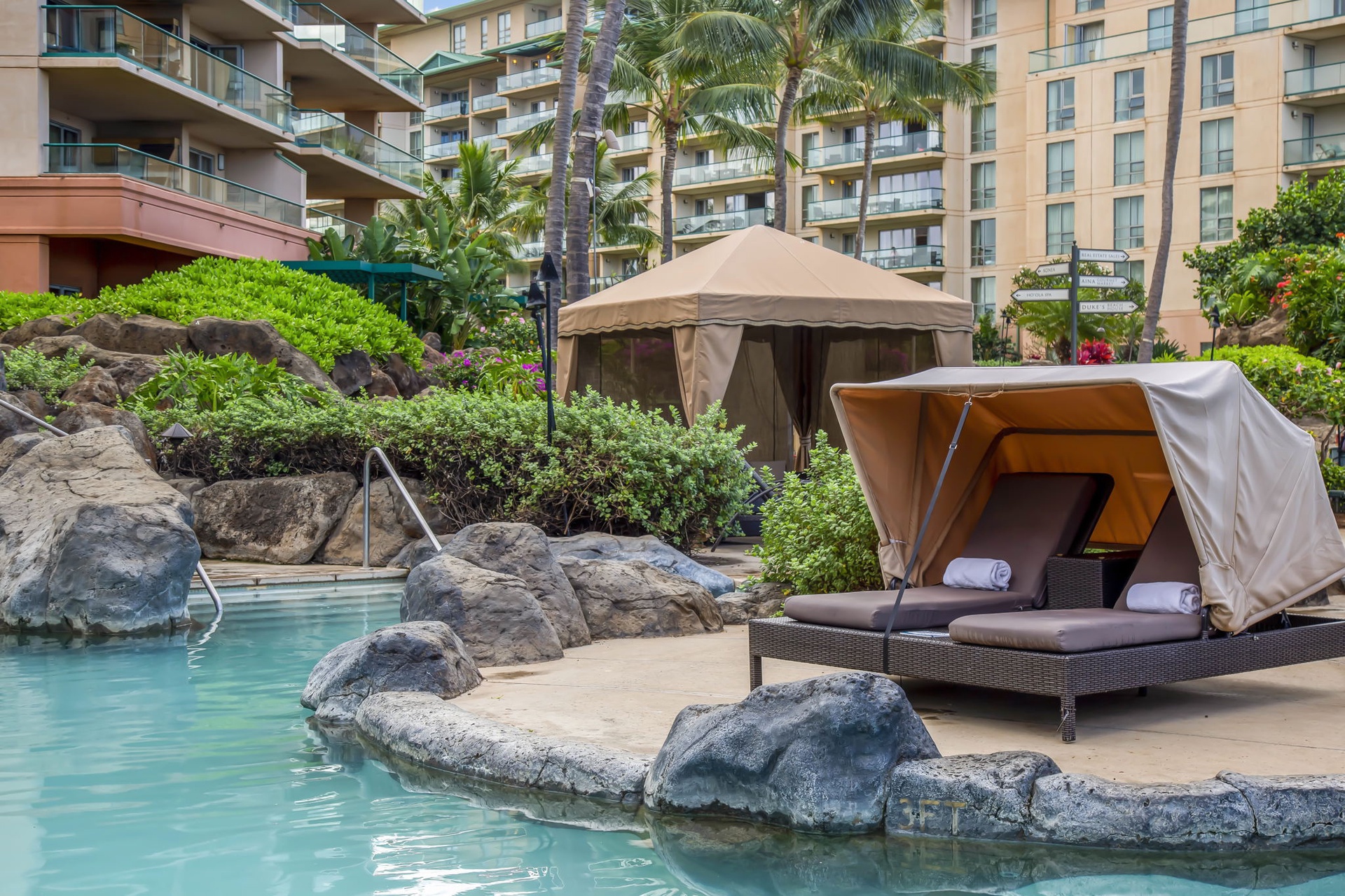 Sink into a luxurious poolside lounger shaded by your private cabana, surrounded by lush tropical gardens and serene lagoon-style waters—your ultimate escape for relaxation.
