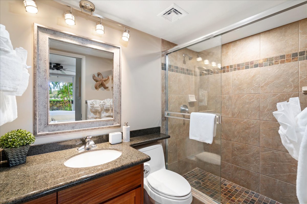 Bright primary bathroom with a glass enclosed shower