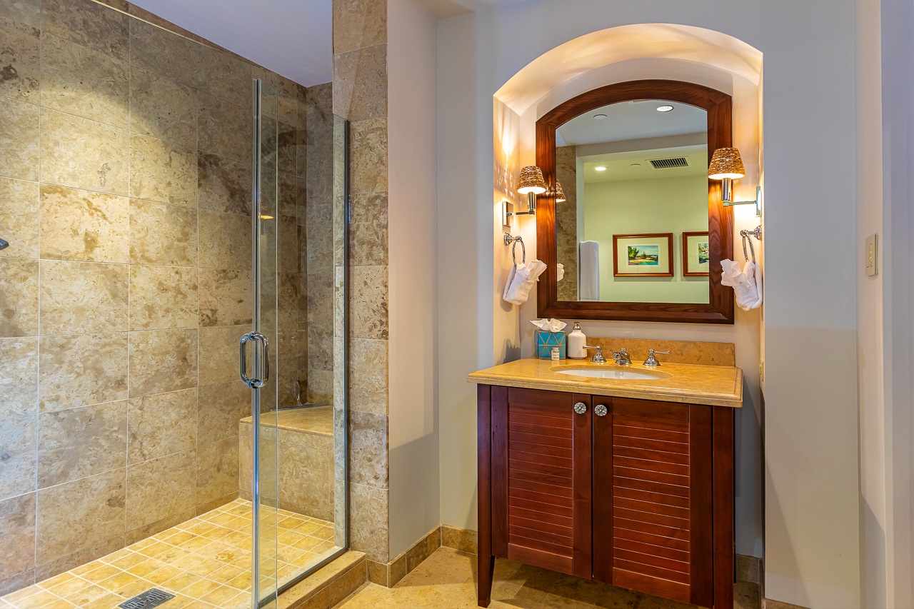 Step into a beautifully appointed bathroom where travertine tile and warm wood accents create a spa-like retreat. Your spacious walk-in shower and elegant vanity await, perfect for unwinding after a day of adventure.