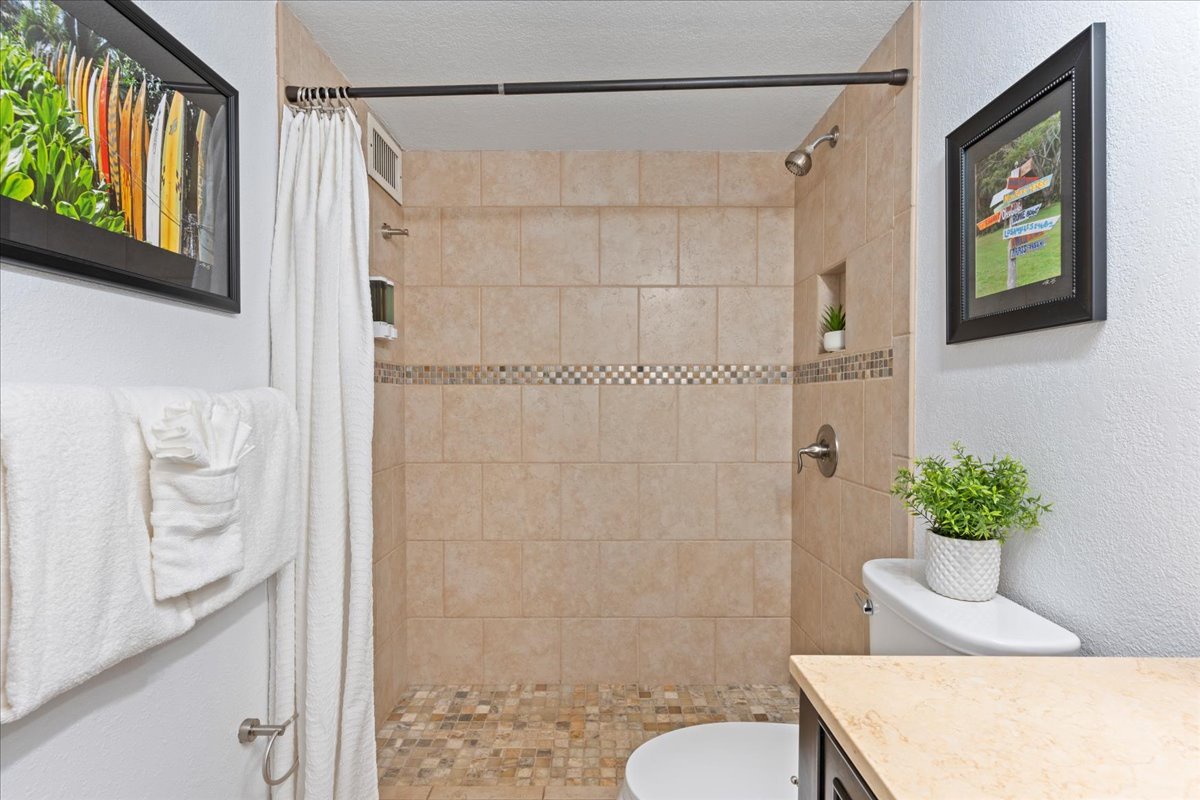Start your day refreshed in the bright and inviting bathroom, offering a convenient space to prepare for island adventures.