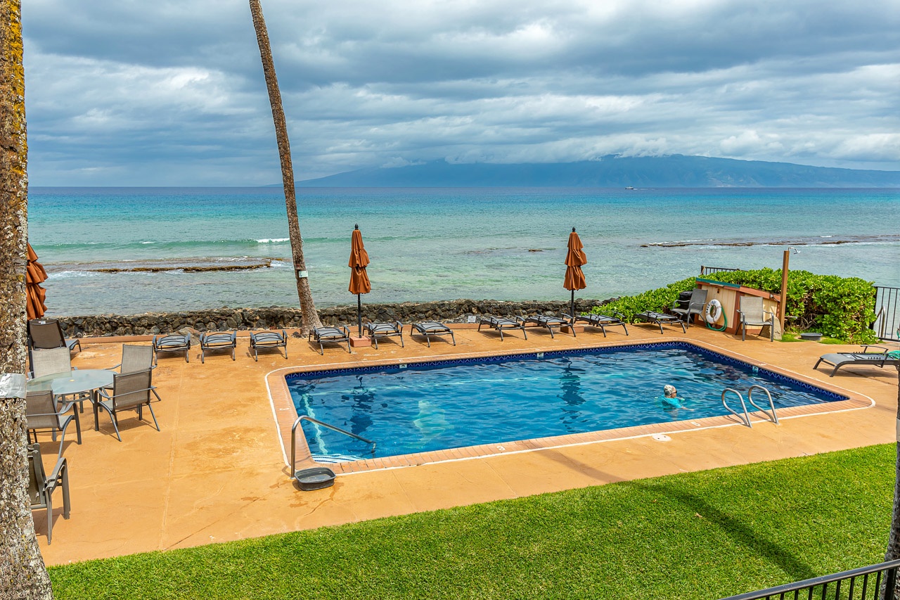 An oceanfront pool with lounge chairs, offering a serene beachside retreat.