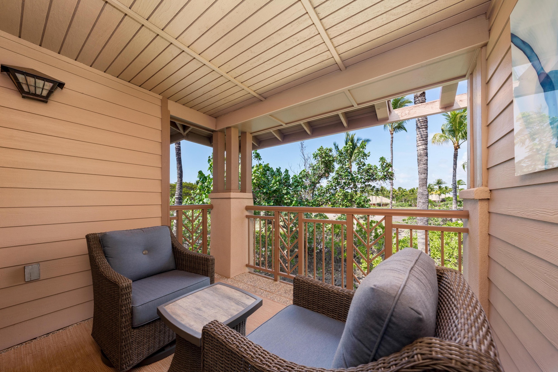 Unwind on your private covered balcony with tropical garden views and comfortable wicker seating for morning coffee or evening relaxation.