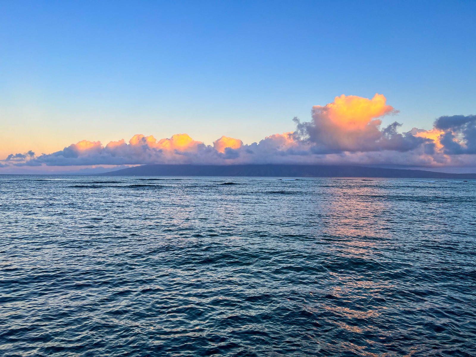 Stunning ocean and sky at dusk, with clouds illuminated in shades of pink and gold over calm waters near the property.