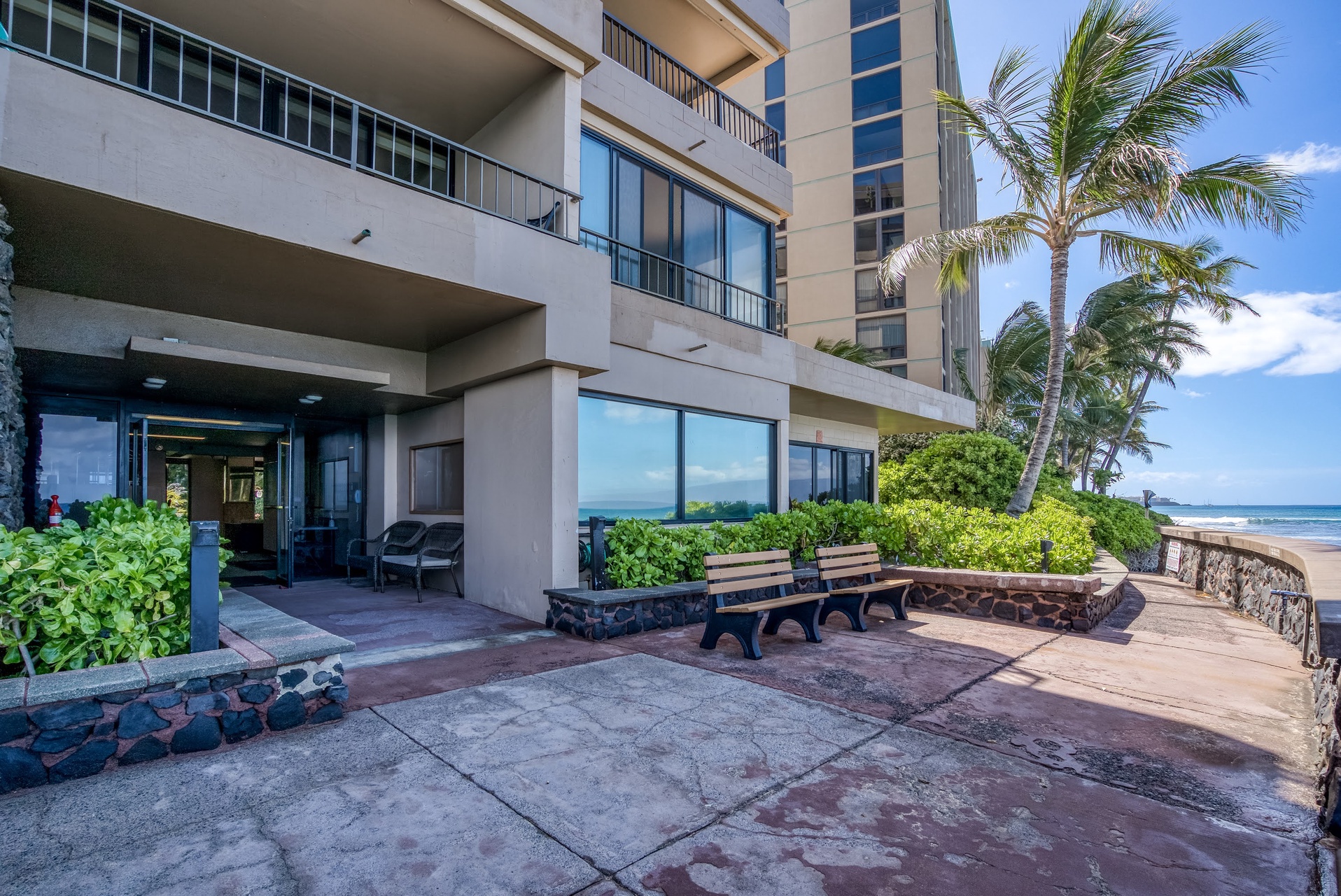 Beachfront property with swaying palms, and ocean views.