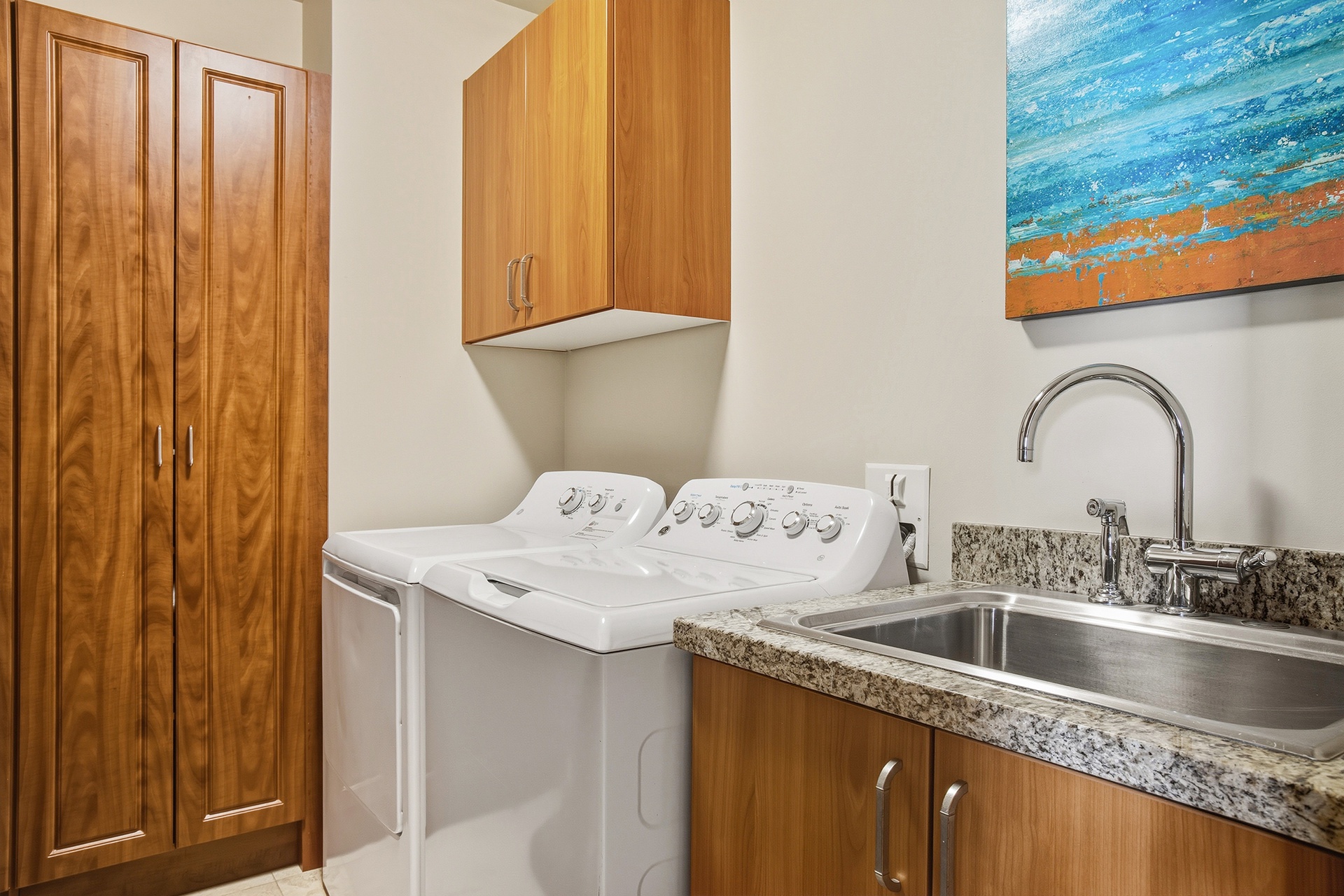 Your dedicated laundry space features modern appliances and granite counters