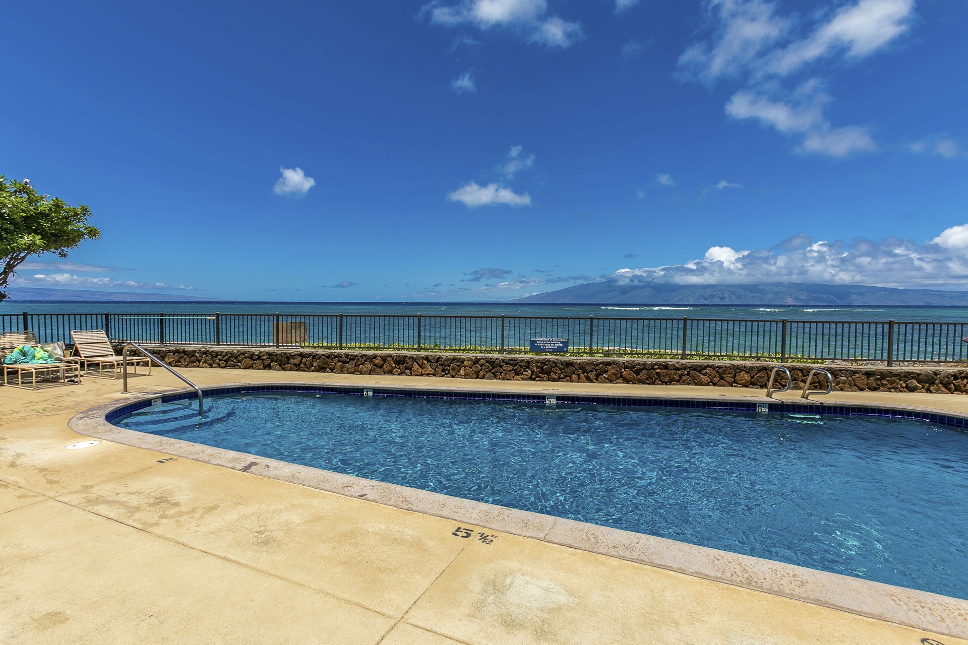 Picture yourself lounging poolside, gazing across turquoise waters toward majestic Molokai mountains on the horizon