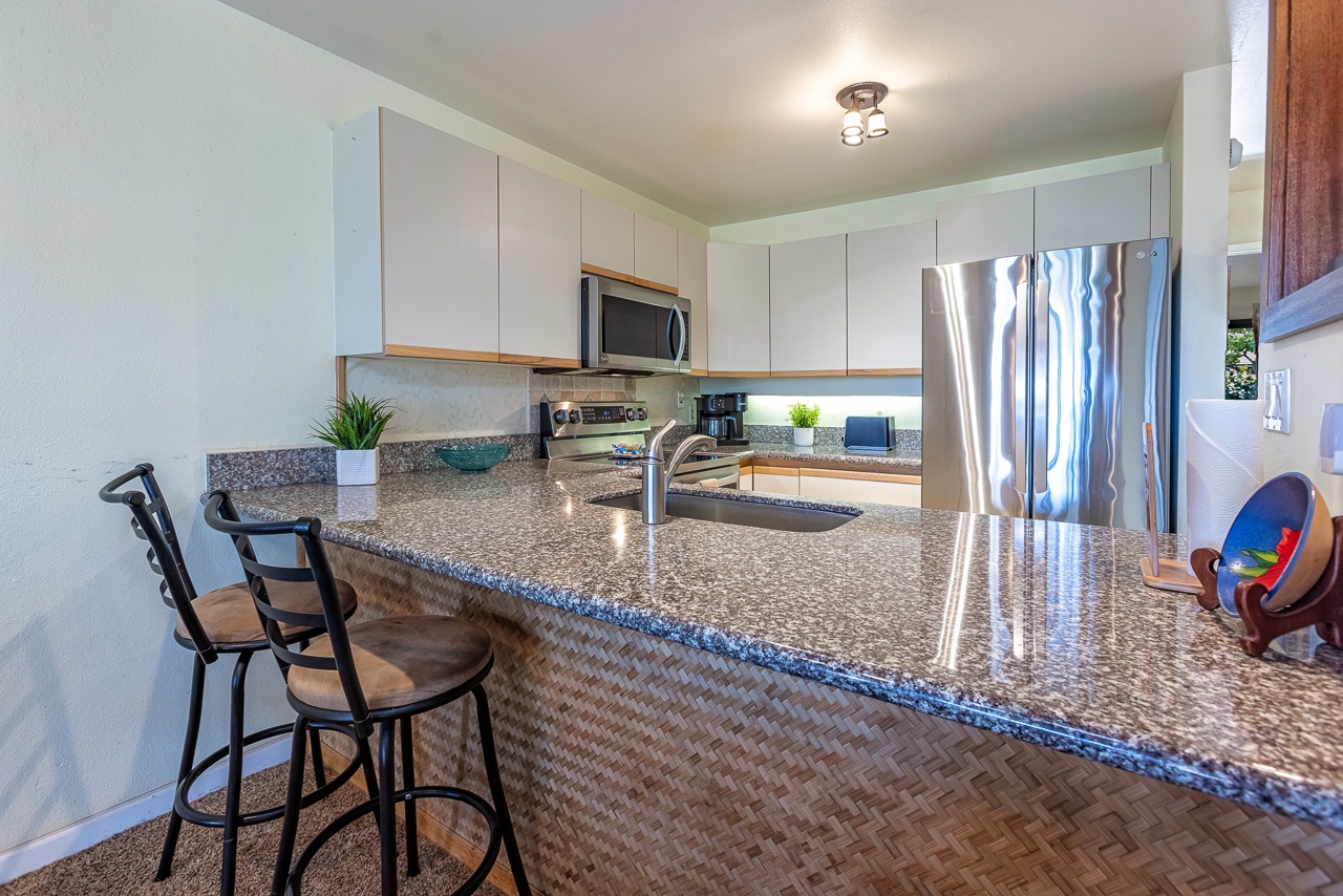 You'll love the sleek, fully equipped kitchen with gleaming granite counters, modern stainless appliances, and bar seating—perfect for prepping your favorite meals or sharing a casual breakfast before your day's adventure.