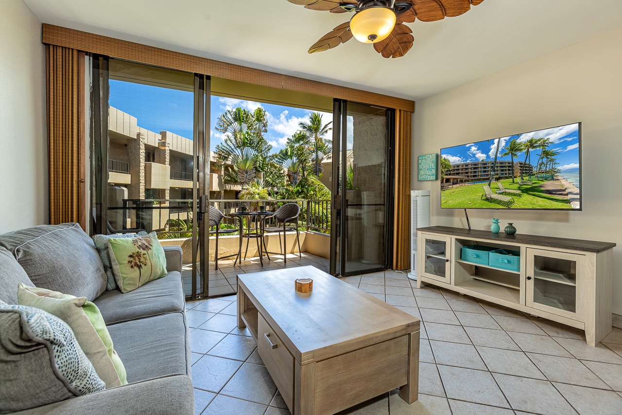 Step into your island sanctuary, where a breezy living room flows seamlessly onto a private lanai framed by tropical palms and blue skies beyond.