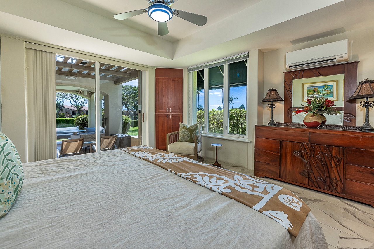 Your serene bedroom retreat opens to a private lanai with pool views, featuring rich tropical wood furnishings, comfortable seating, and soothing decor that invite relaxation.