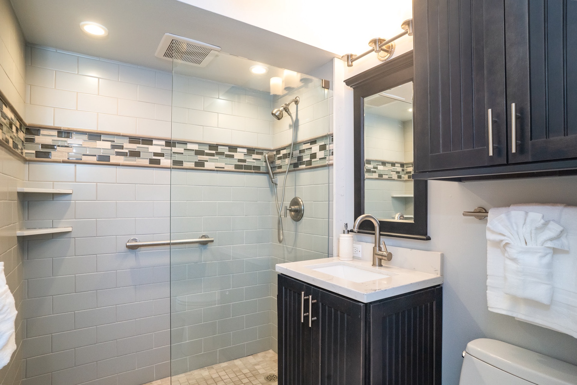 The private bathroom features a walk-in shower, a vanity with ample storage, and freshly folded towels awaiting your arrival.
