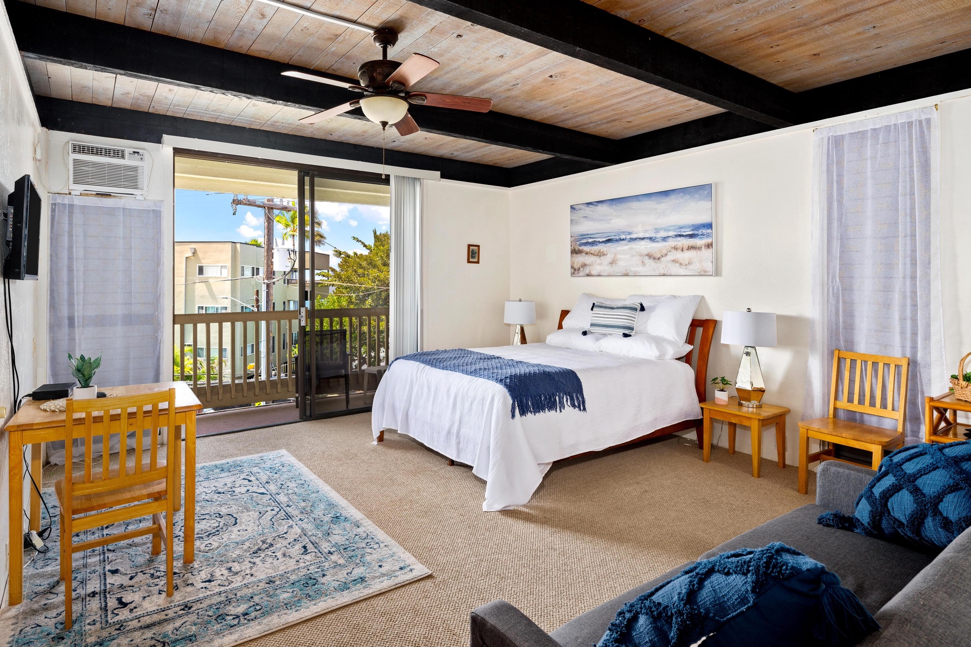 Sink into crisp white linens and wake to morning light streaming through your private balcony doors. Rustic wood beams meet coastal charm in your thoughtfully appointed retreat.