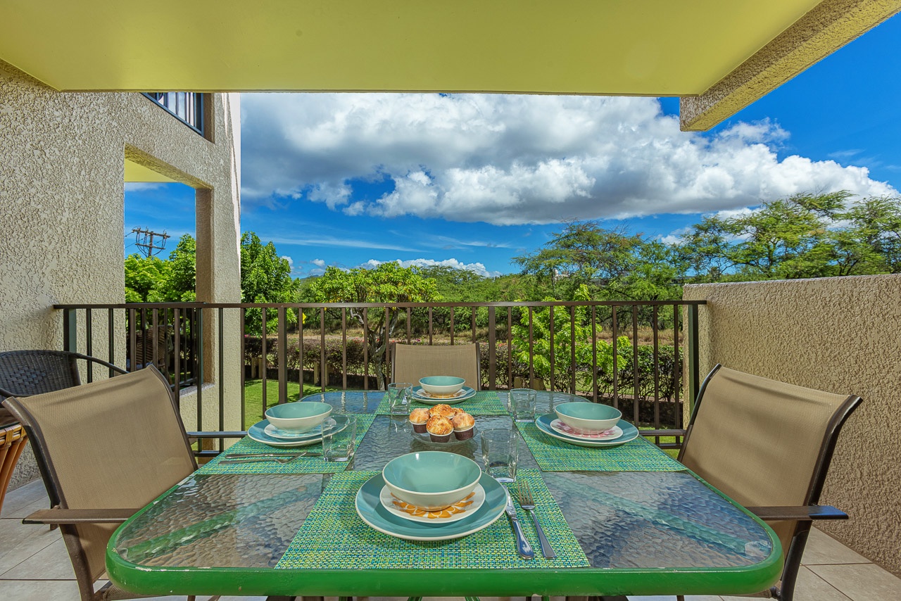 Enjoy your morning coffee or evening meals on this covered balcony, where a cheerful table awaits and lush greenery surrounds you.