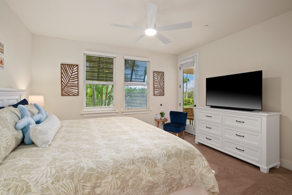 Relax in this bright bedroom featuring a plush king bed, tropical décor, and convenient TV entertainment for your perfect getaway.