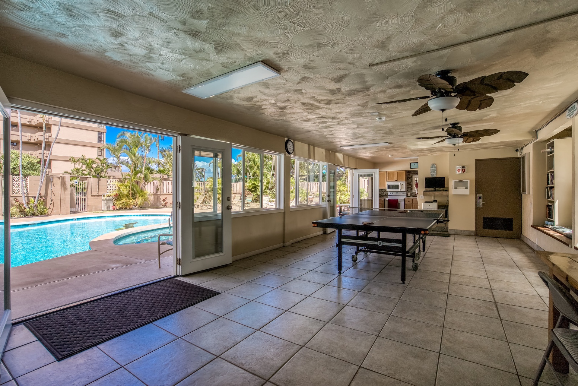 Step into your communal game room where sunlight dances across the ceiling, reflecting the pool's ripples.