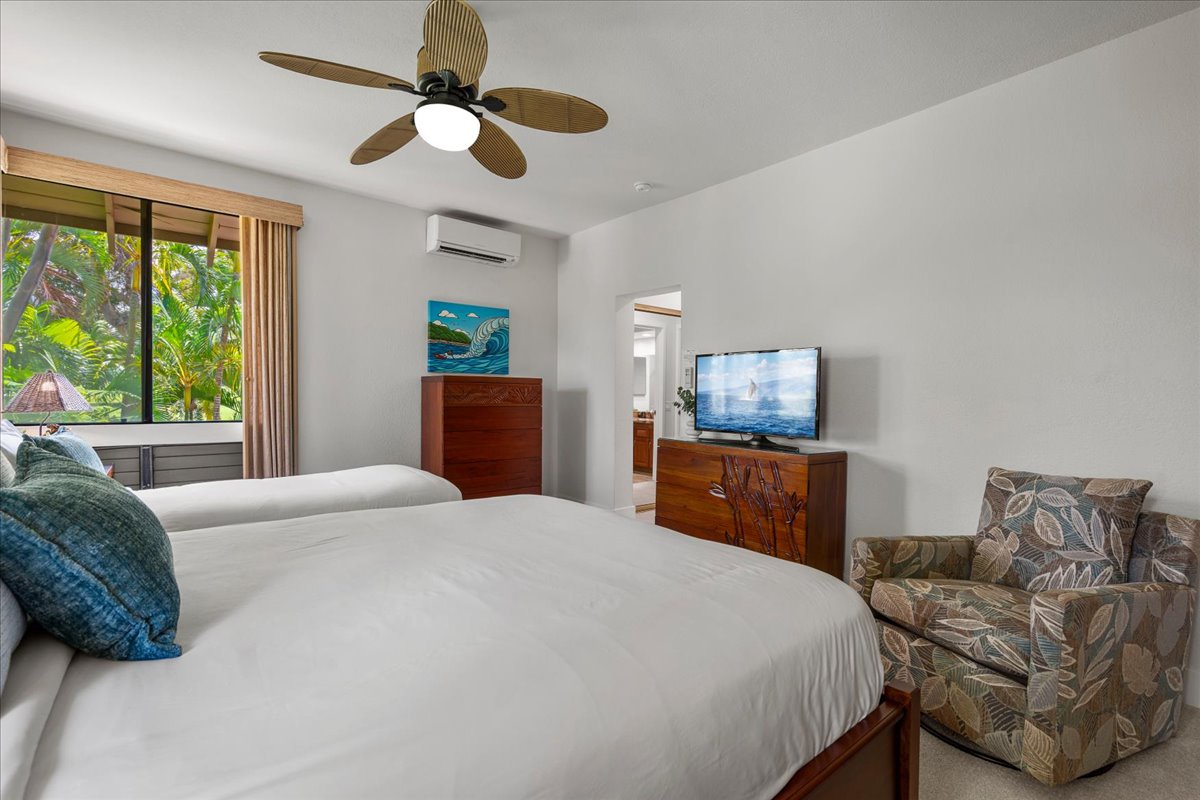 Relax in your bright, breezy bedroom with twin beds, tropical views, a cozy armchair, and modern entertainment. The ceiling fan and AC keep you cool after island adventures.