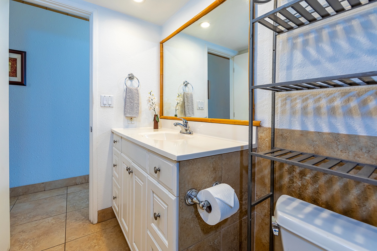 A bright, thoughtfully designed bathroom awaits you with a spacious vanity, large mirror, and walk-in shower with elegant tilework—your perfect retreat after a day of exploring.