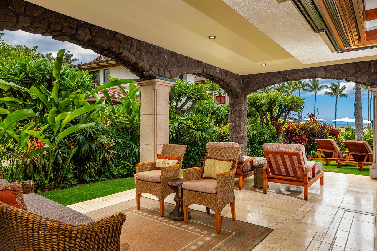 Settle into your private covered lanai surrounded by lush tropical gardens and ocean views. Comfortable seating invites you to sip morning coffee or unwind as palm trees sway in the warm Hawaiian breeze.
