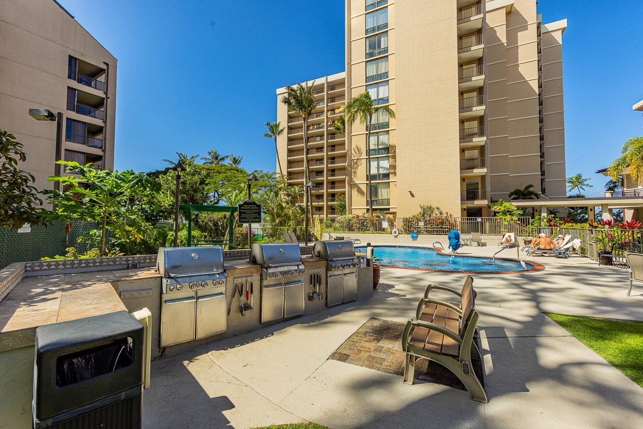 This tropical property features a spacious pool deck with outdoor grilling stations and plenty of sunny relaxation spots, all framed by swaying palms and nearby mountains.