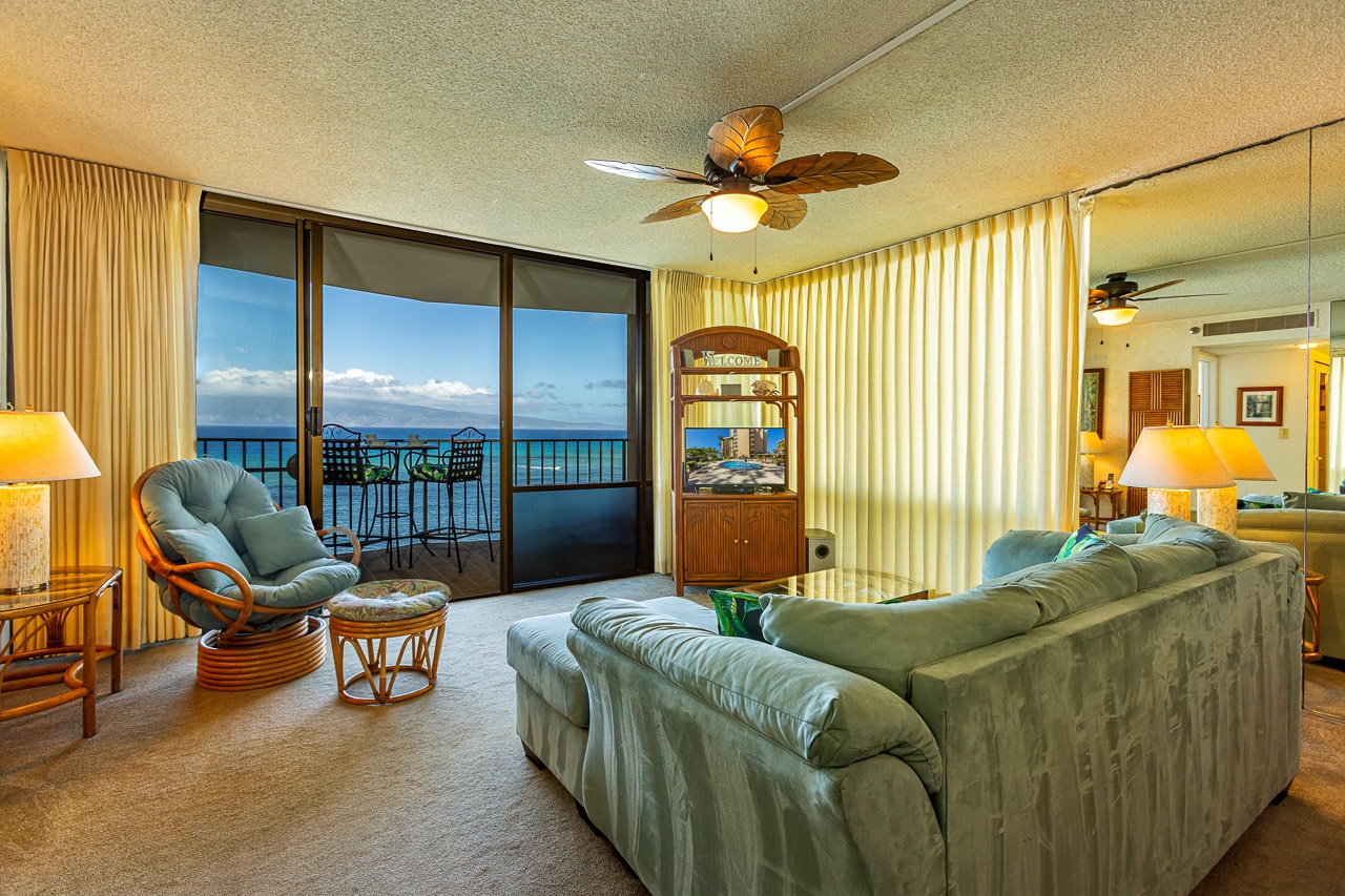 Sink into comfort in this inviting living room with breathtaking ocean views through your private lanai. The tropical ceiling fan and warm island-style furnishings create your perfect Hawaiian retreat.