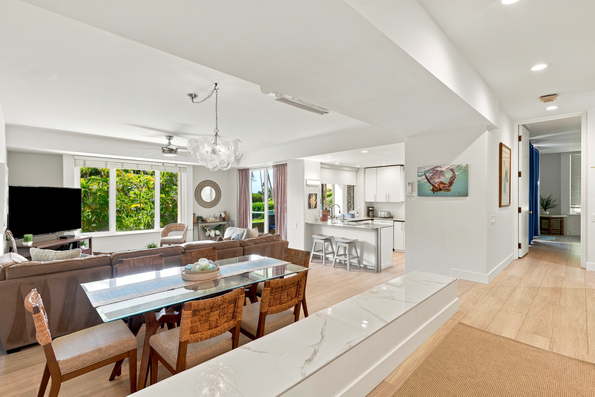 Step into your bright, airy living space where gleaming floors and soaring ceilings create an effortless flow. Large windows frame lush greenery, while your modern kitchen and stylish dining area invite shared moments and relaxed gatherings.