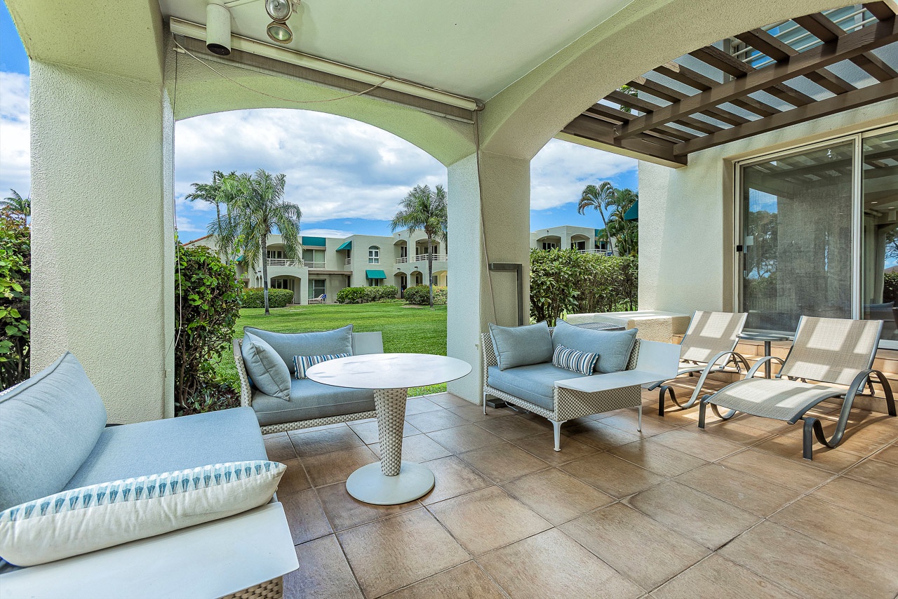 Unwind in this covered patio featuring plush seating and peaceful garden views—your perfect spot to relax with morning coffee or enjoy the gentle island breeze.
