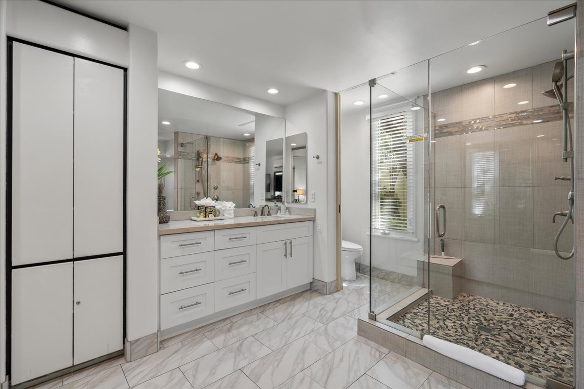 Spacious primary bathroom with beautifully tiled glass shower