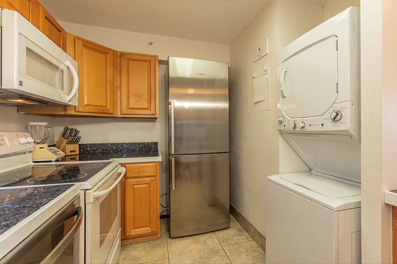 Cook and clean with ease in a kitchen featuring washer and dryer