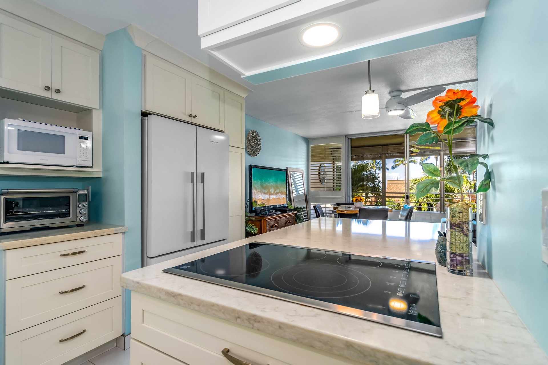 Your bright, fully equipped kitchen invites you to prepare fresh island meals, with modern appliances and calming coastal colors that blend seamlessly into the open living space beyond.