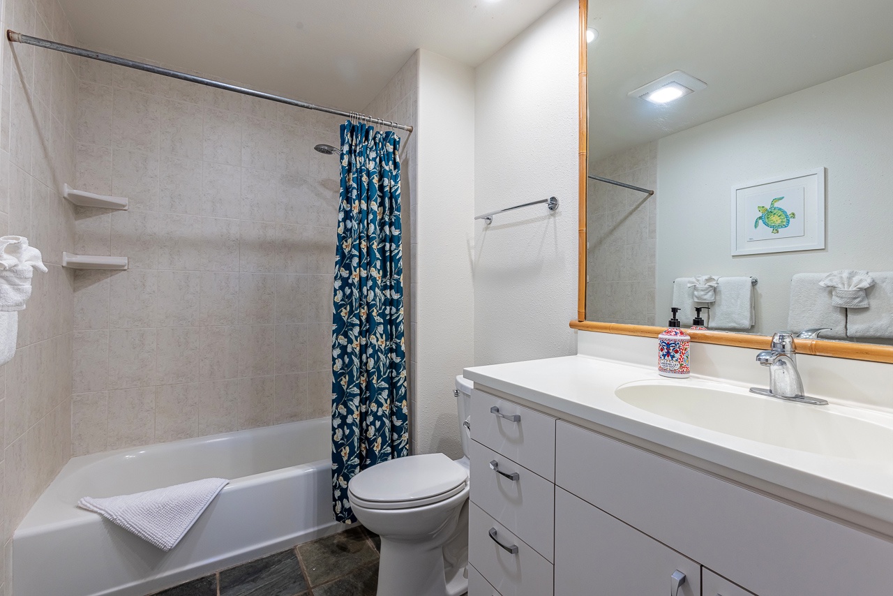 Freshen up in your private bathroom with a full tub-shower combo, plenty of vanity space, and coastal-themed touches that bring a cheerful, beachy vibe to your morning routine.