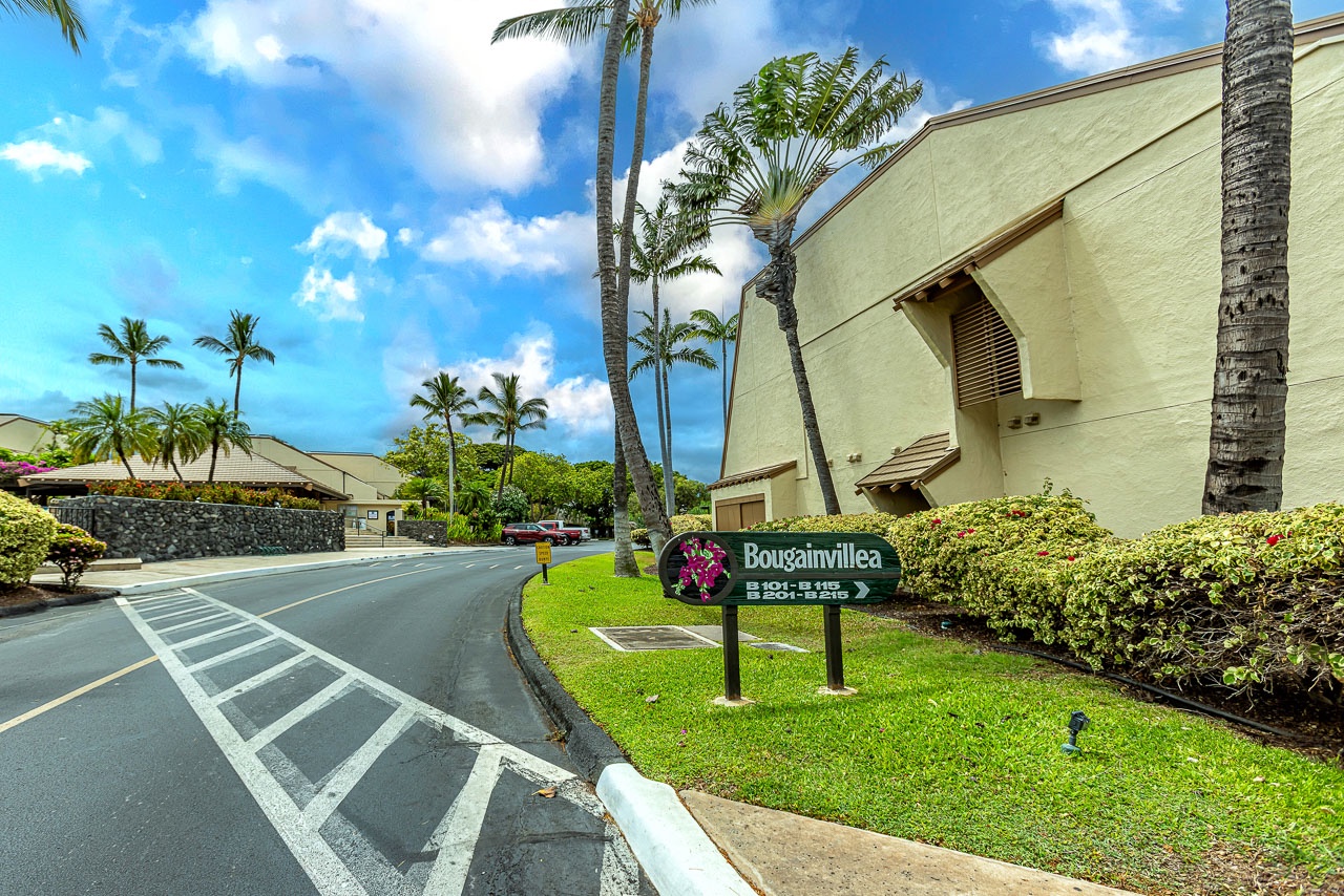 The property entrance welcomes you under swaying palms and bright blue skies, marking your arrival in this tropical haven.