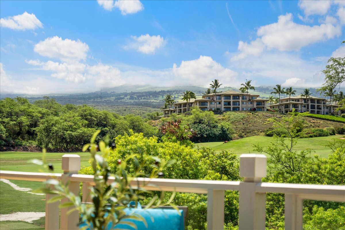 A peaceful resort nestled among lush tropical greenery, with rolling hills and distant mountains creating a serene backdrop for a tranquil island getaway.