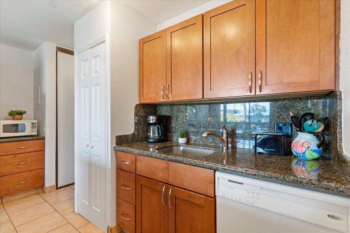 Your fully equipped kitchen features warm wood cabinetry, granite countertops, and modern appliances—perfect for brewing morning coffee or preparing a home-cooked meal during your stay.