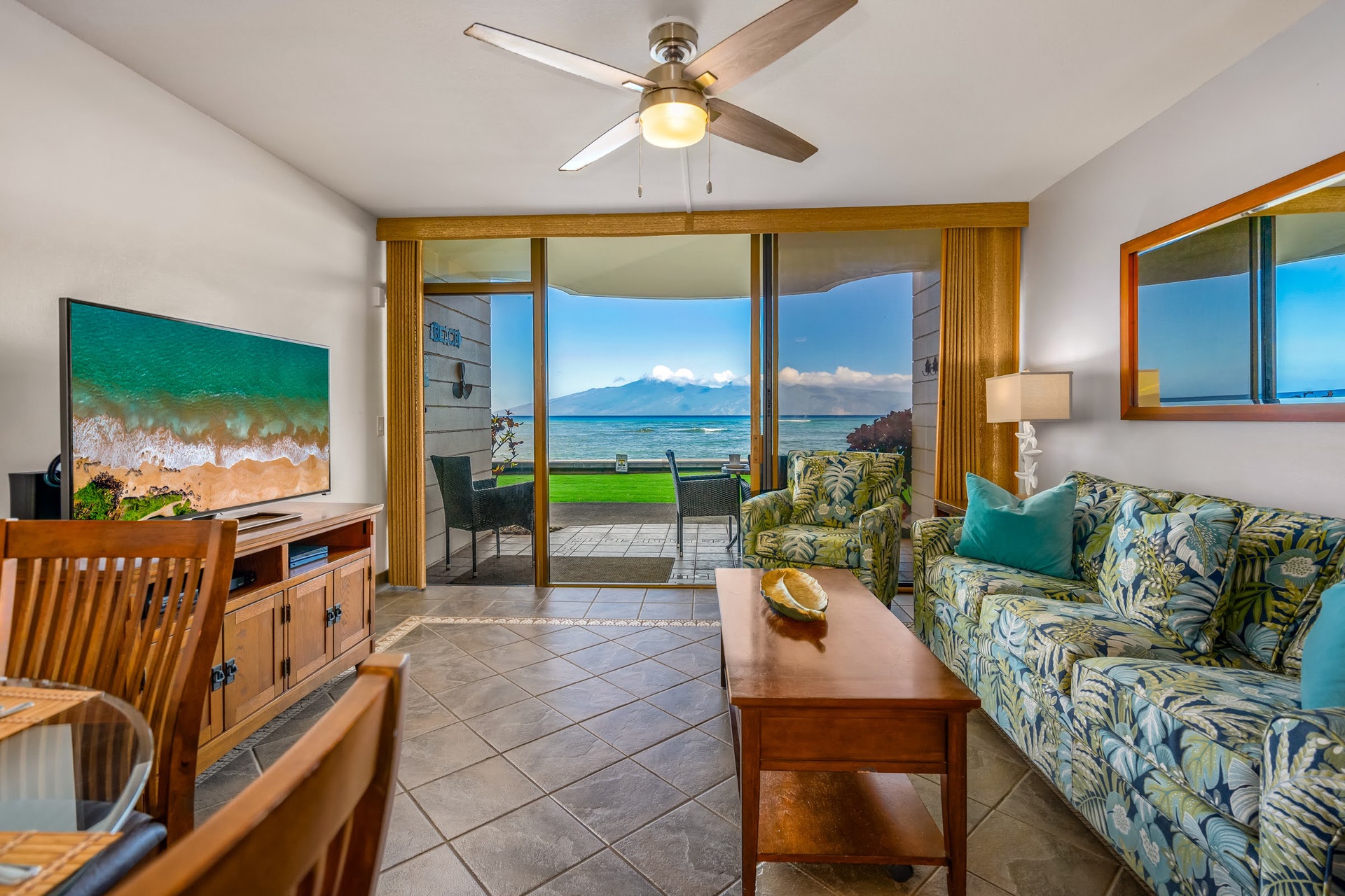 Floor-to-ceiling windows frame stunning ocean views, flooding the open living and dining space with natural light.