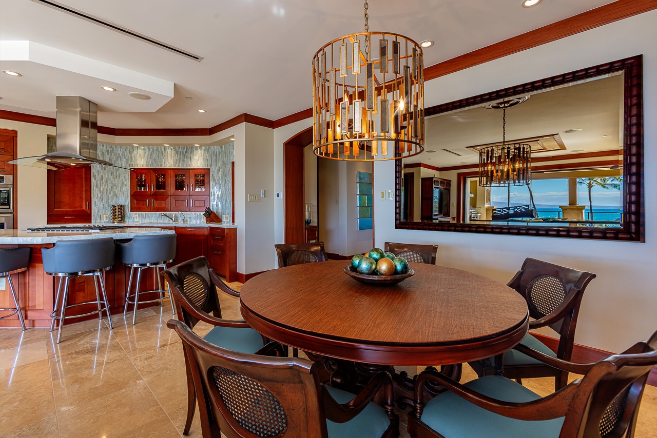 Gather around this inviting dining table with ocean views reflecting in the mirror, or relax at the kitchen island with bar seating—your perfect setup for memorable meals together.